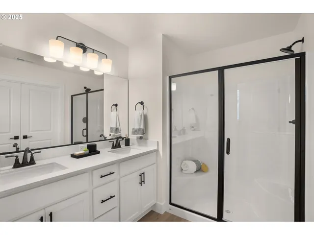 a bathroom with a double vanity sink mirror double and shower