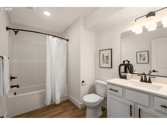 a bathroom with a sink a toilet a large mirror and shower