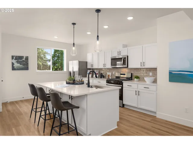 a kitchen with microwave a sink refrigerator dining table and chairs