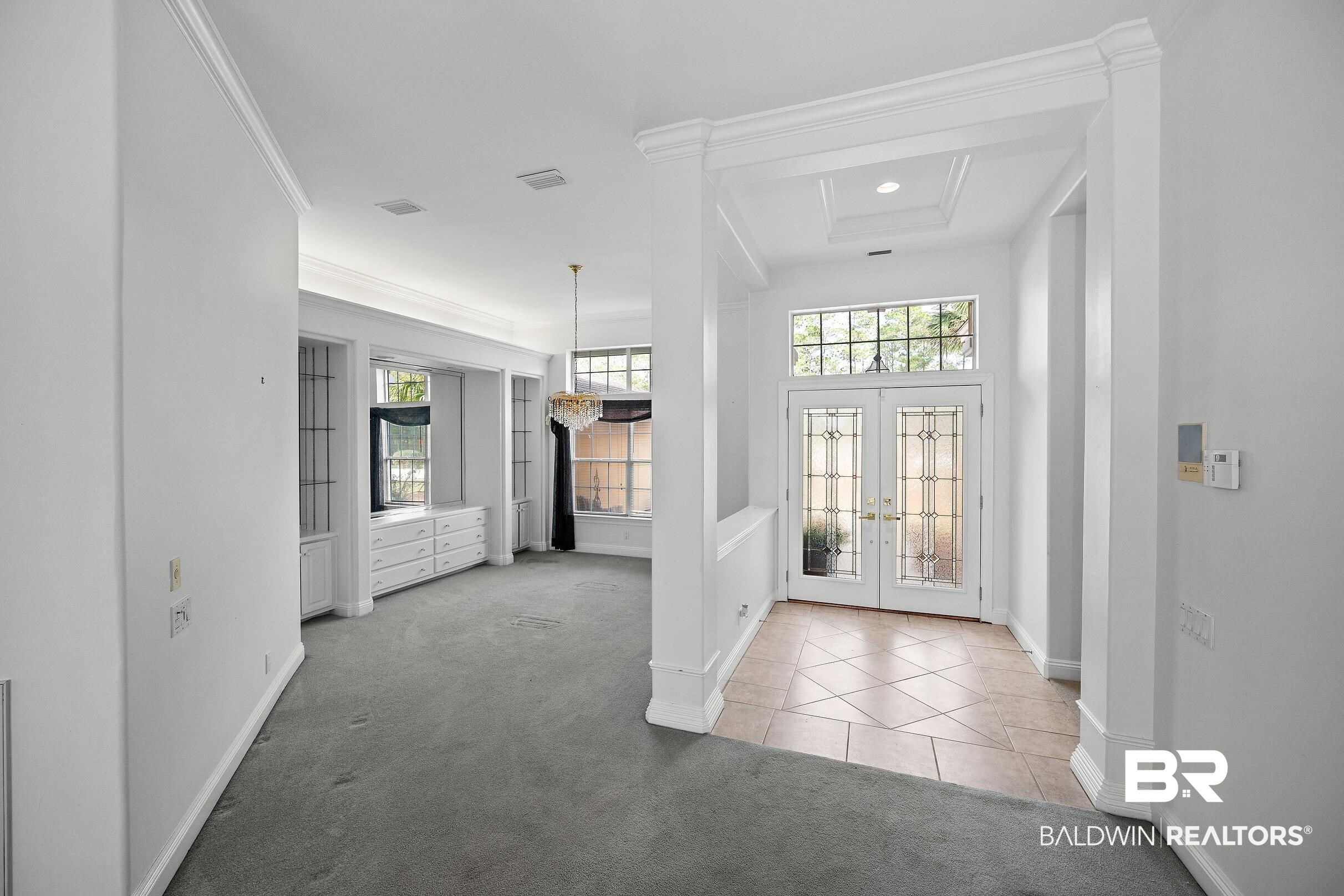 8591 Bay Harbor Road Elberta, AL 36530 - Photo 22 of 56 Foyer featuring light colored carpet, french doors, light tile patterned flooring, and crown molding