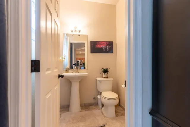 a bathroom with a toilet sink and mirror