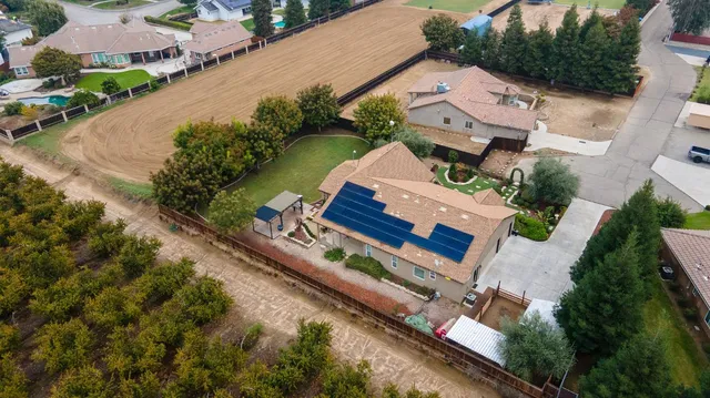 an aerial view of a house with outdoor space and a lake view in back