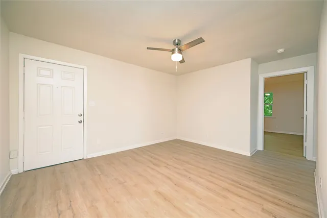 an empty room with closet and a ceiling fan