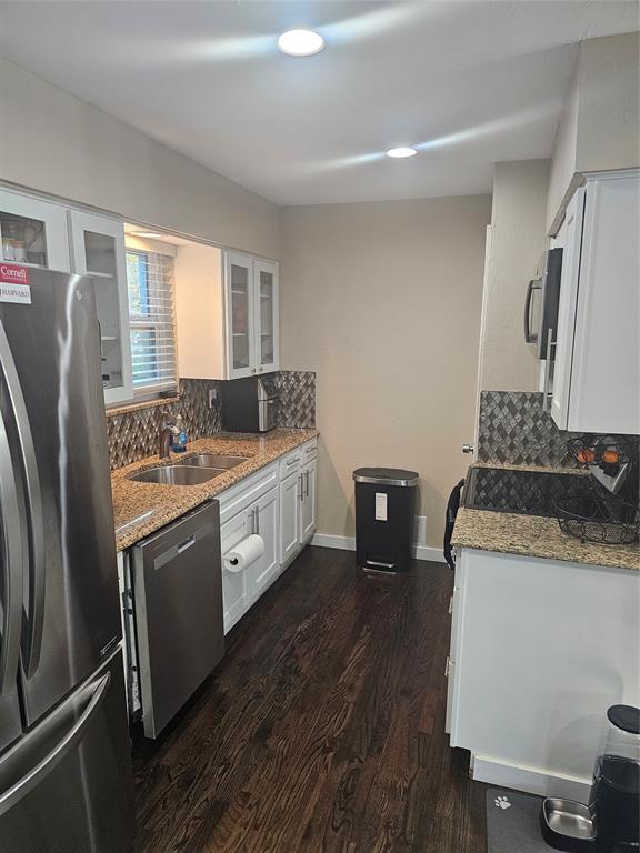 9911 Ferguson Road Dallas, TX 75228 - Photo 5 of 18 Kitchen with tasteful backsplash, light stone countertops, white cabinets, fridge, and recessed lighting