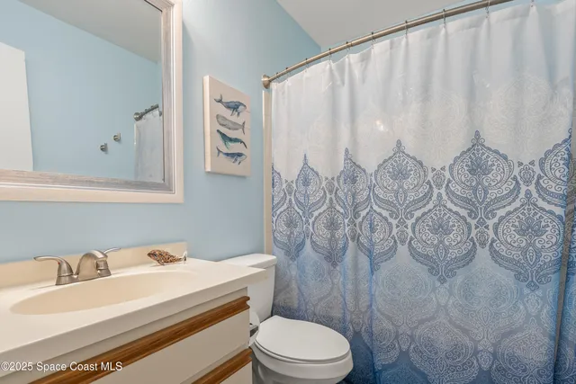 a view of a tennis ground with large trees