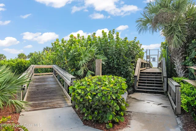 a front view of a house with a garden and trees