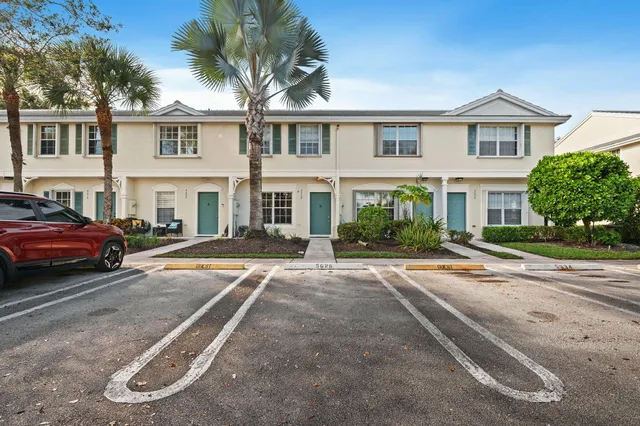 a front view of a house with a garden and parking