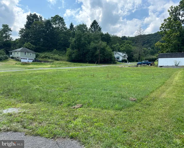 a view of a green field with wooden fence