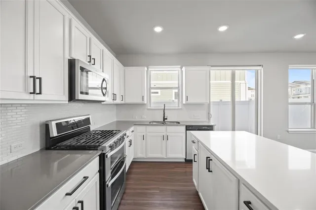 a kitchen with a sink stove top oven and cabinets