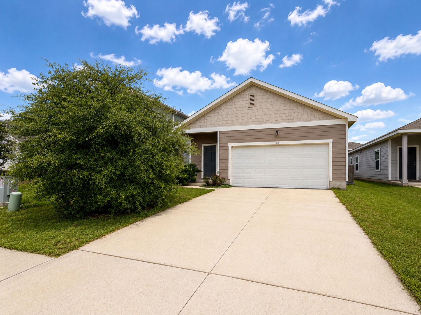 160 Light Timber Road Maxwell, TX 78656 - Photo 1 of 11 A welcoming facade showcases a broad driveway leading to an integrated garage, set against a vibrant green lawn.