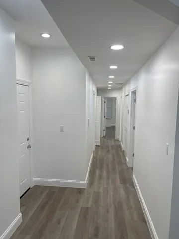 a view of a hallway with wooden floor