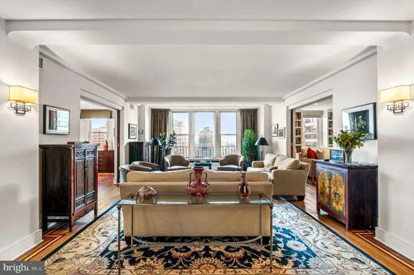 a living room with furniture large window and wooden floor