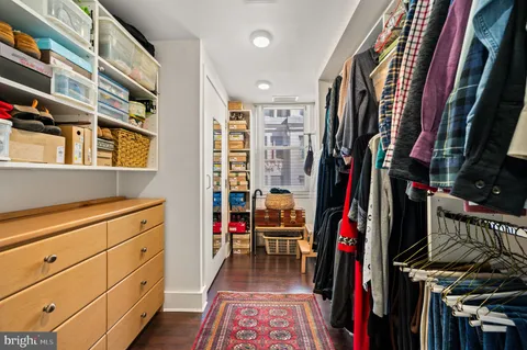 a view of walk in closet with clothes and shoes