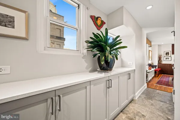 a hallway with white cabinets and wooden floor