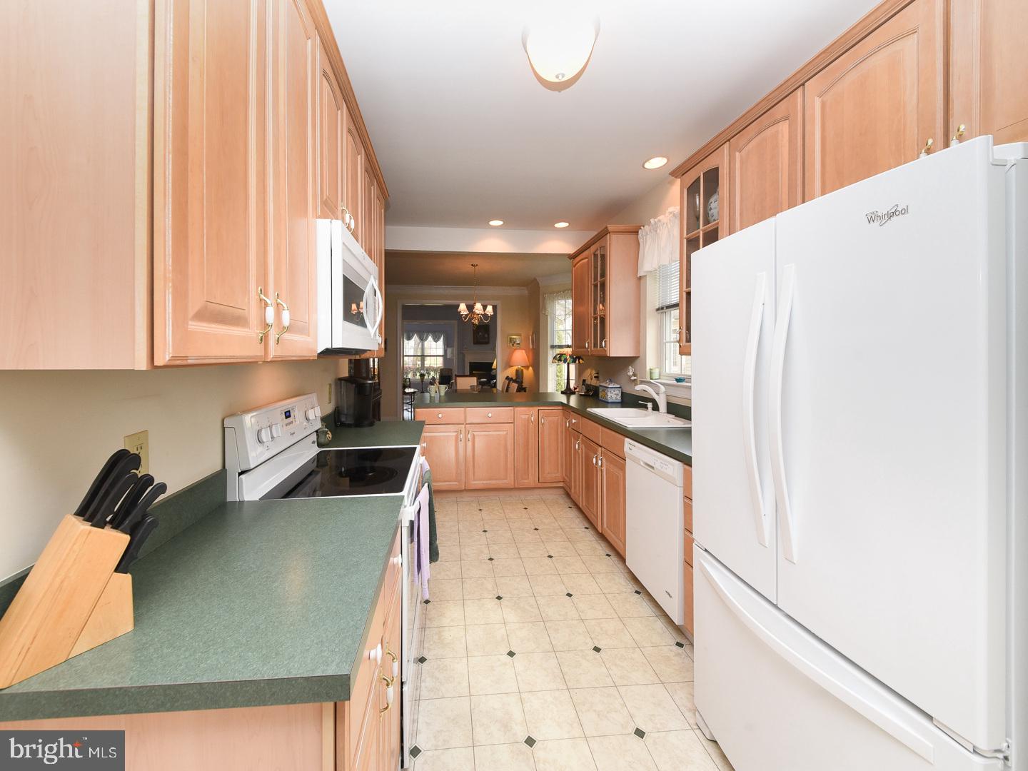 3113 Arborgreene Court Hatfield, PA 19440 - Photo 7 of 33 a kitchen with granite countertop a refrigerator a sink a stove and white cabinets