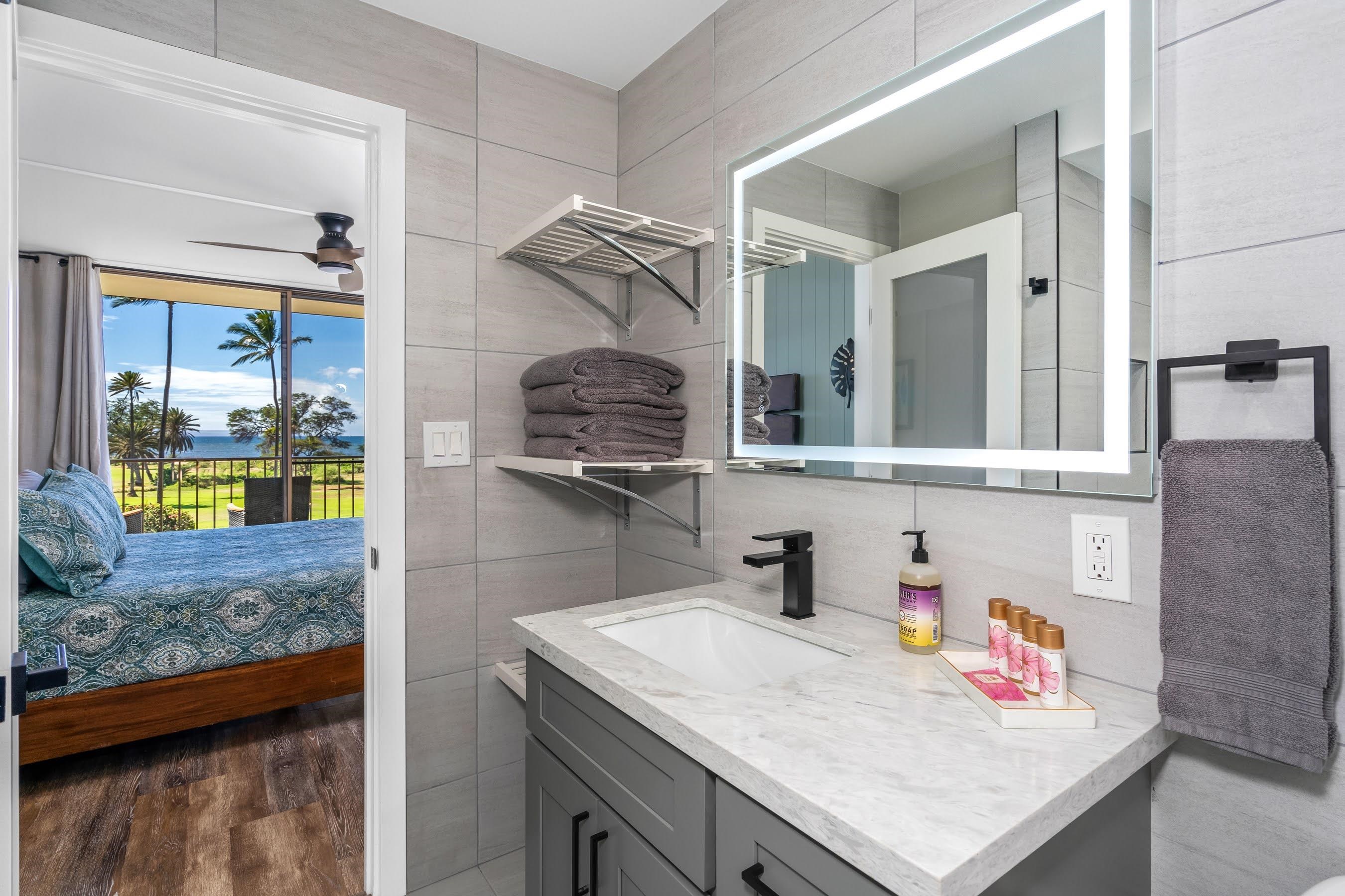 938 South Kihei Road, Unit 309 Kihei, HI 96753 - Photo 18 of 34 a bathroom with a granite countertop sink and a mirror