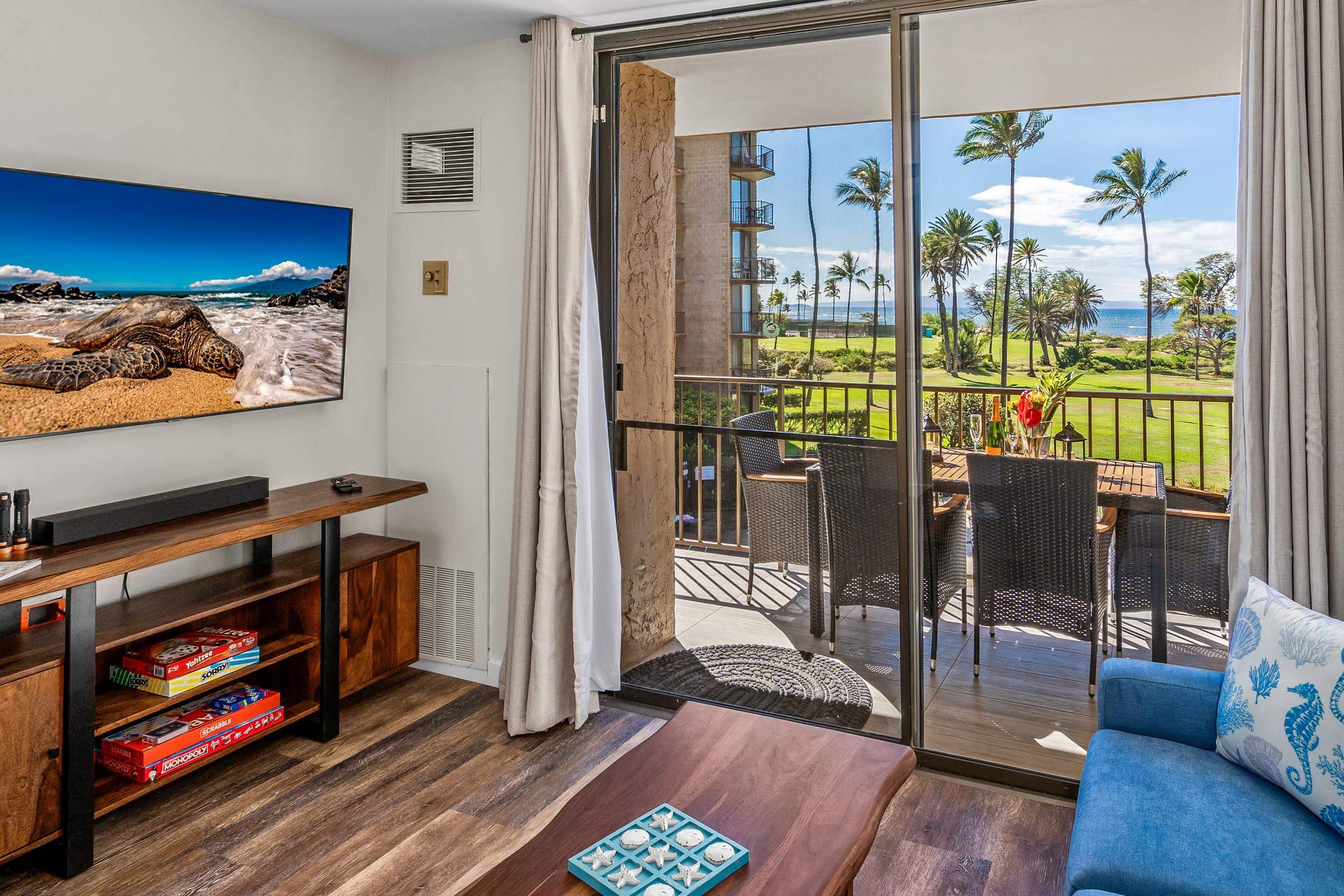 938 South Kihei Road, Unit 309 Kihei, HI 96753 - Photo 2 of 34 a living room with furniture a flat screen tv and floor to ceiling window