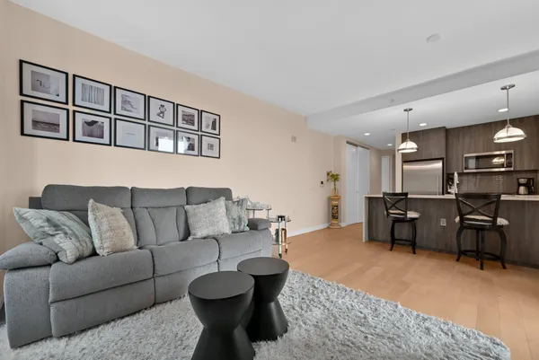 a living room with furniture kitchen view and a window