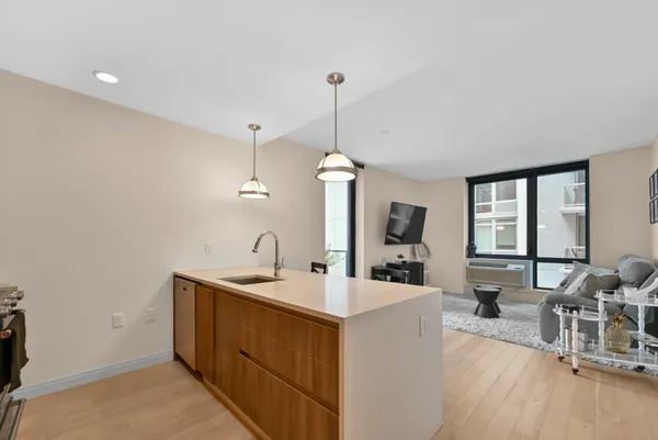a kitchen with a sink a counter top space and living room area