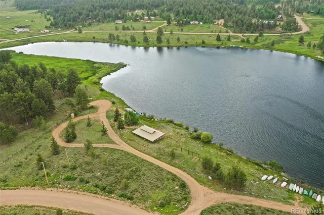 an aerial view of a house with a yard and lake view