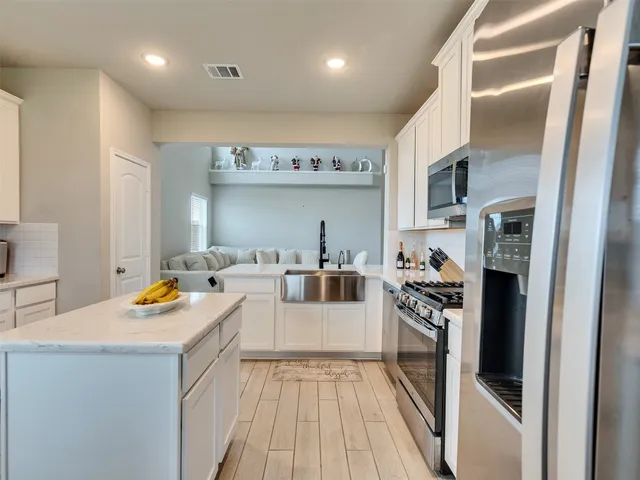 a kitchen with stainless steel appliances a stove a sink dishwasher and a refrigerator