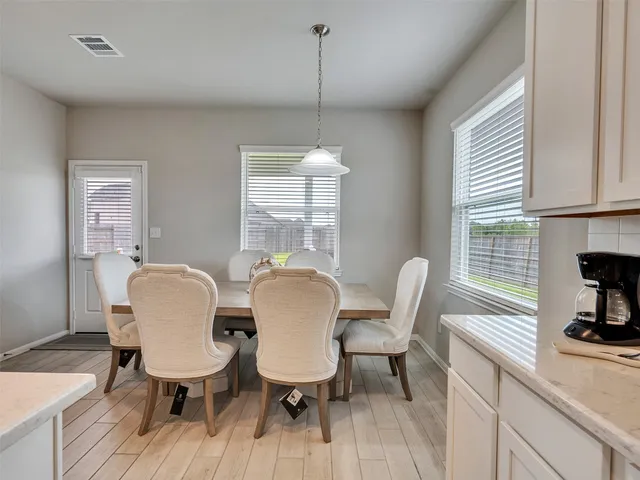 a dining room with furniture a window and wooden floor