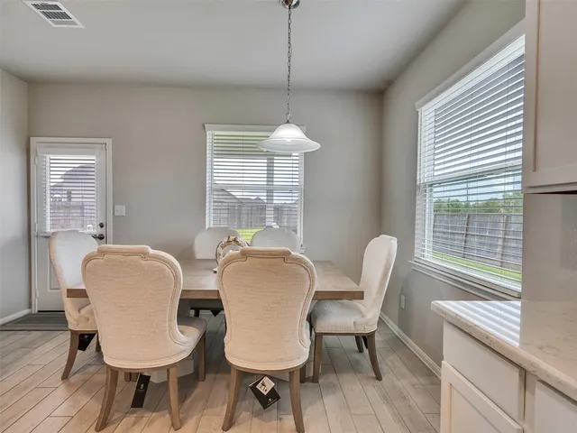 a dining room with furniture a chandelier and wooden floor