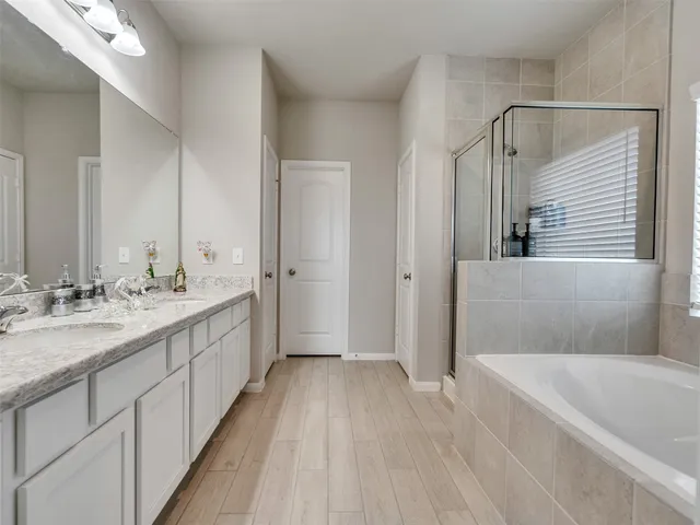 a bathroom with a tub sink and mirror