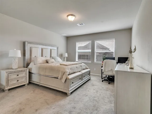 a bedroom with a bed and a large window