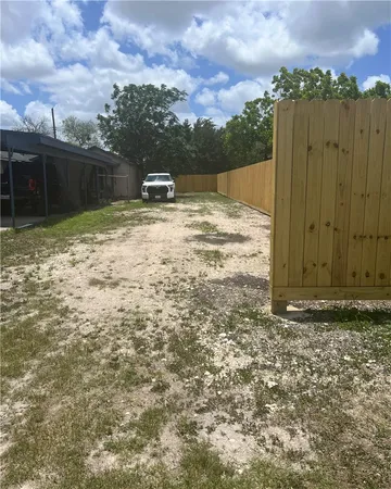 a view of a backyard with wooden fence