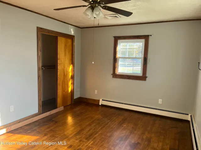 a view of an empty room with a window and a ceiling fan