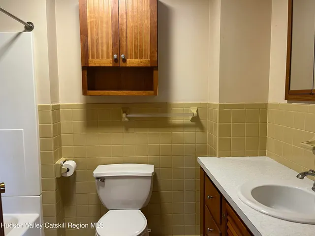 a bathroom with a sink a toilet and mirror