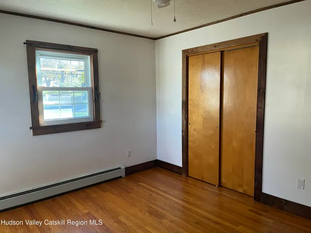 an empty room with wooden floor and a window