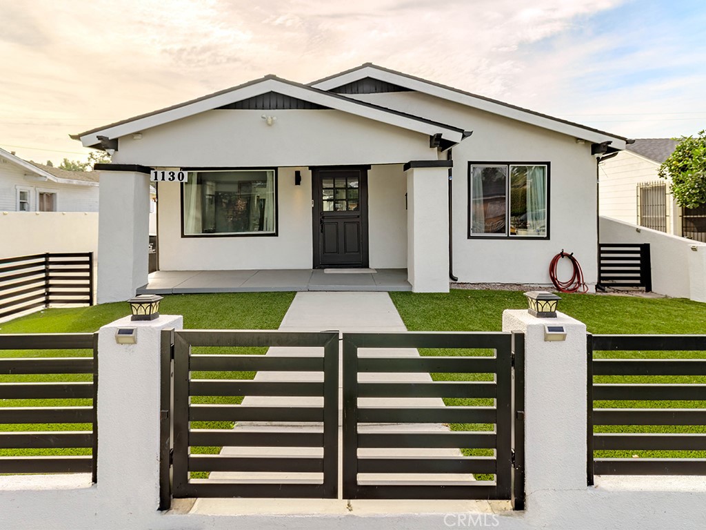 1130 West Chestnut Avenue Santa Ana, CA 92703 - Photo 1 of 20 a view of a white house with a big yard plants and large tree