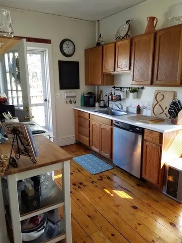 a kitchen with a sink a stove cabinets and a window