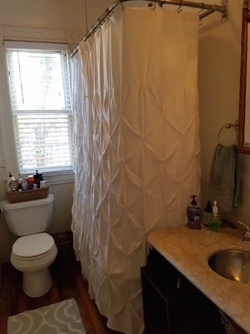 a bathroom with a granite countertop sink toilet and a mirror