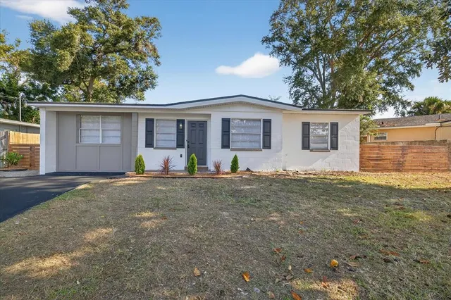 a view of a backyard with a barbeque and large trees