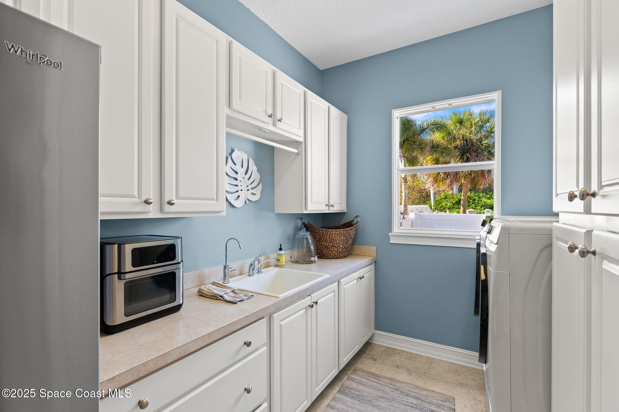 133 Windemere Place Melbourne Beach, FL 32951 - Photo 28 of 75 a kitchen with stainless steel appliances white cabinets and a window