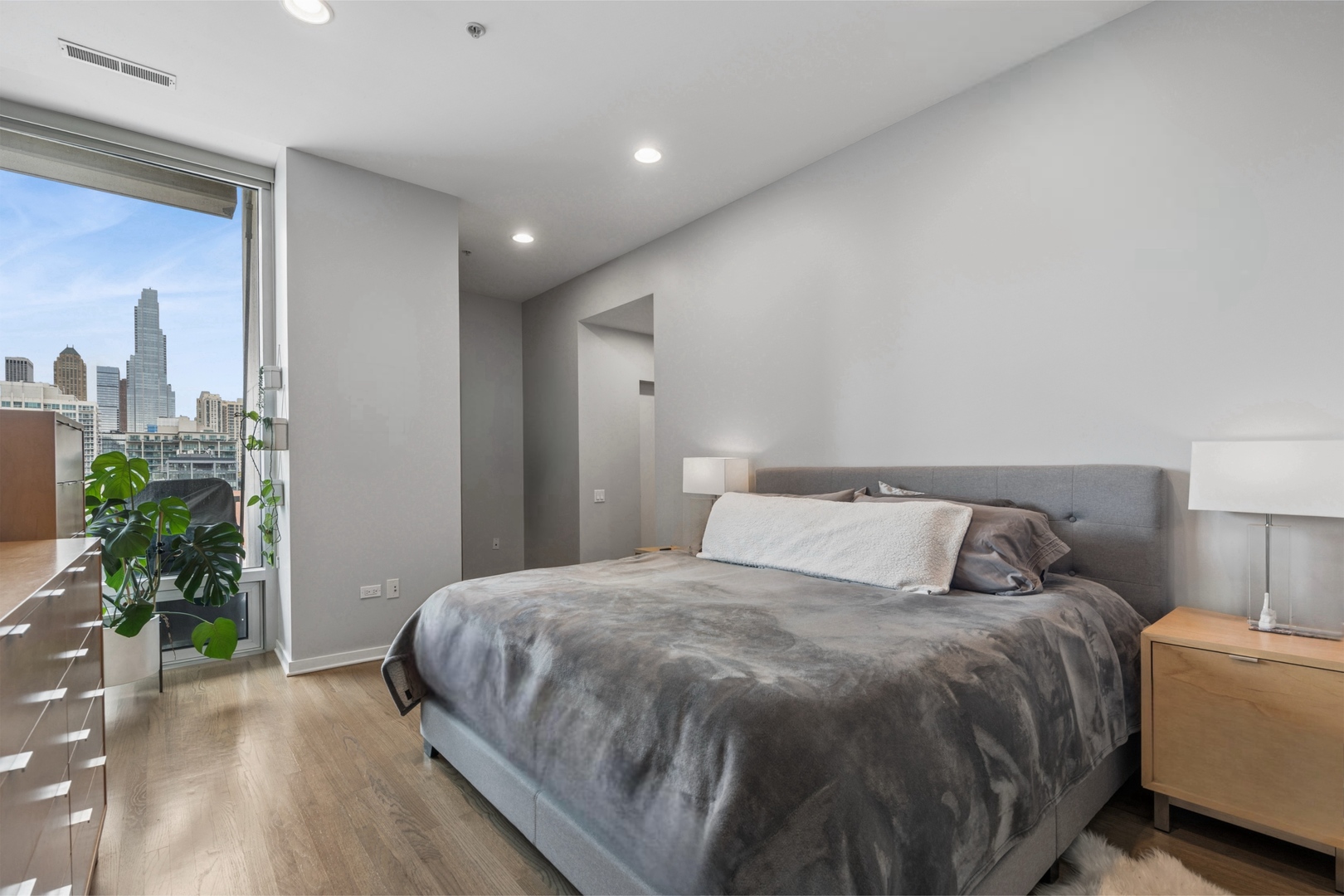 500 West Superior Street, Unit 813 Chicago, IL 60654 - Photo 8 of 18 a bedroom with a bed and a potted plant