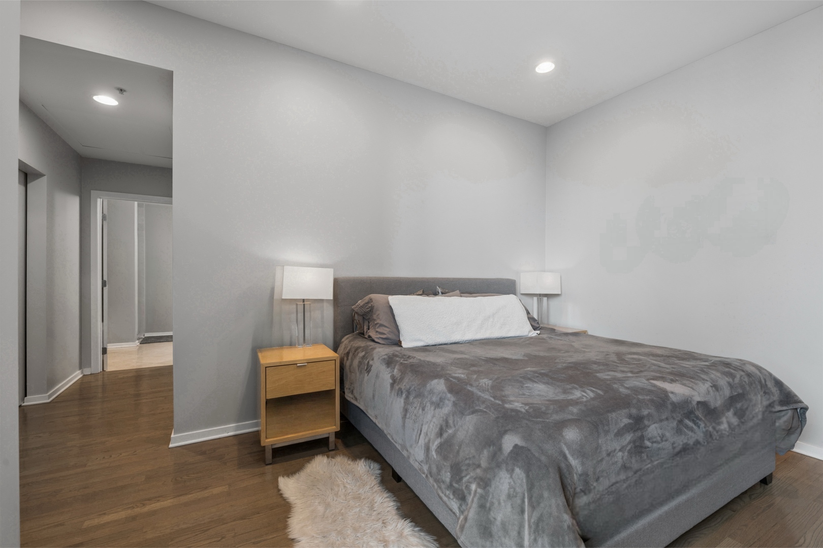 500 West Superior Street, Unit 813 Chicago, IL 60654 - Photo 9 of 18 a bedroom with a bed and wooden floor