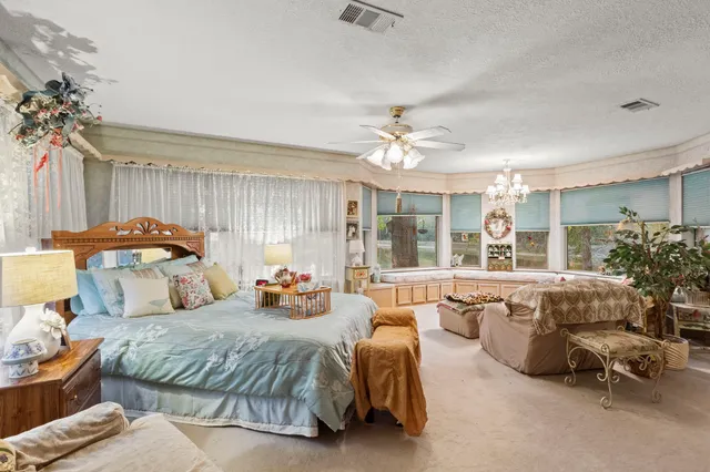 a spacious bedroom with a bed and a chandelier