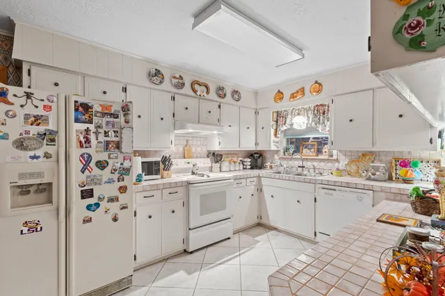 a kitchen with white cabinets sink and white appliances