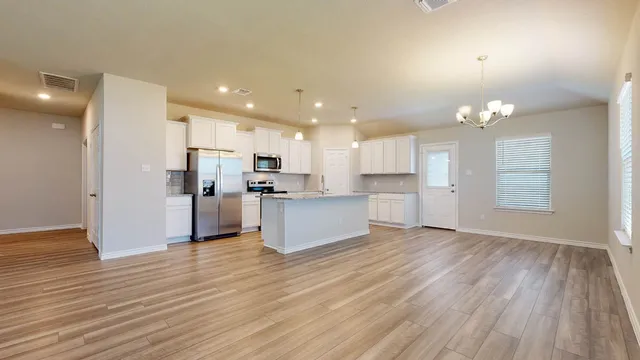a view of kitchen view wooden floor cabinets and stainless steel appliances