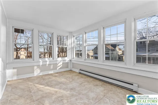 a large white kitchen with granite countertop a stove a sink and a large window