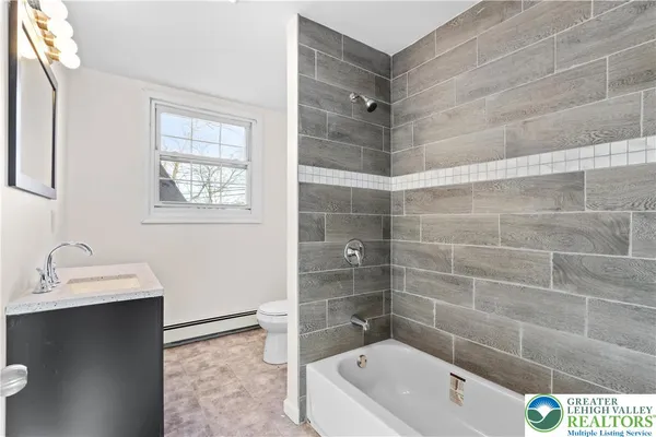 a bathroom with a tub a sink and a shower