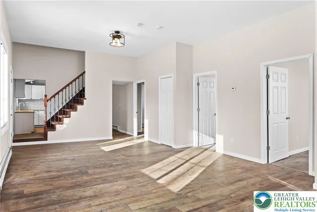 a view of a hallway with wooden floor and staircase