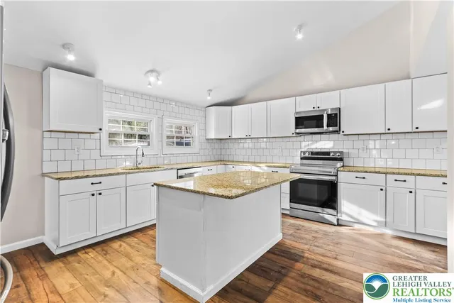 a kitchen with granite countertop a sink and appliances