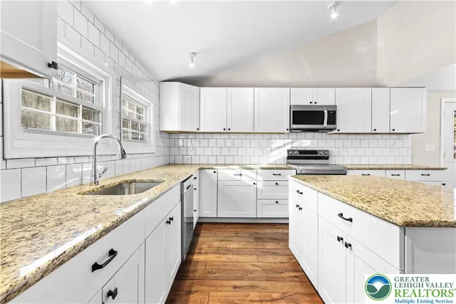 a kitchen with granite countertop a sink stove and cabinets