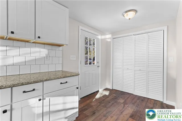 a kitchen with granite countertop white cabinets and white appliances