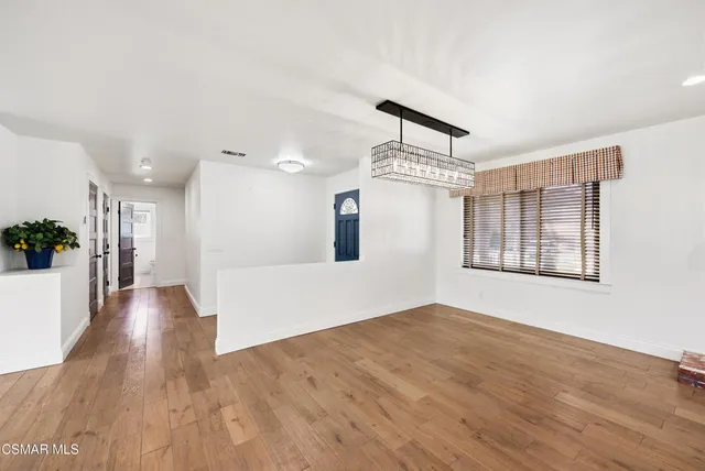 a kitchen with cabinets appliances and wooden floor
